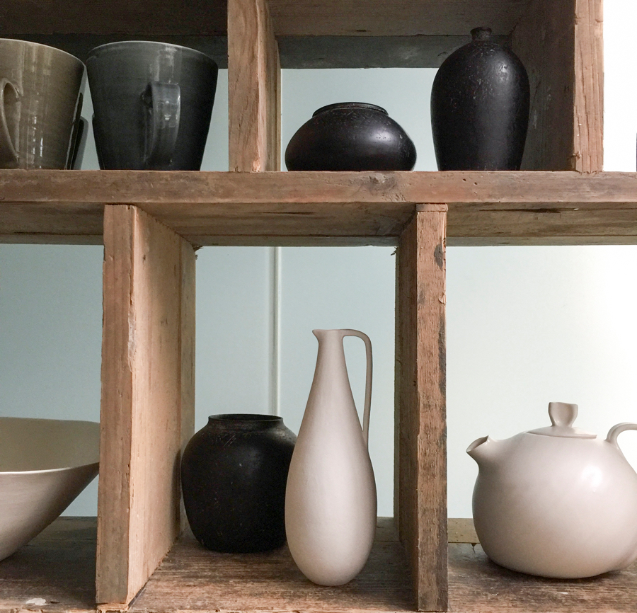 Black and white ceramic jugs, bowls and vases displayed on a Japanese Tansu shelf at Maud & Mabel