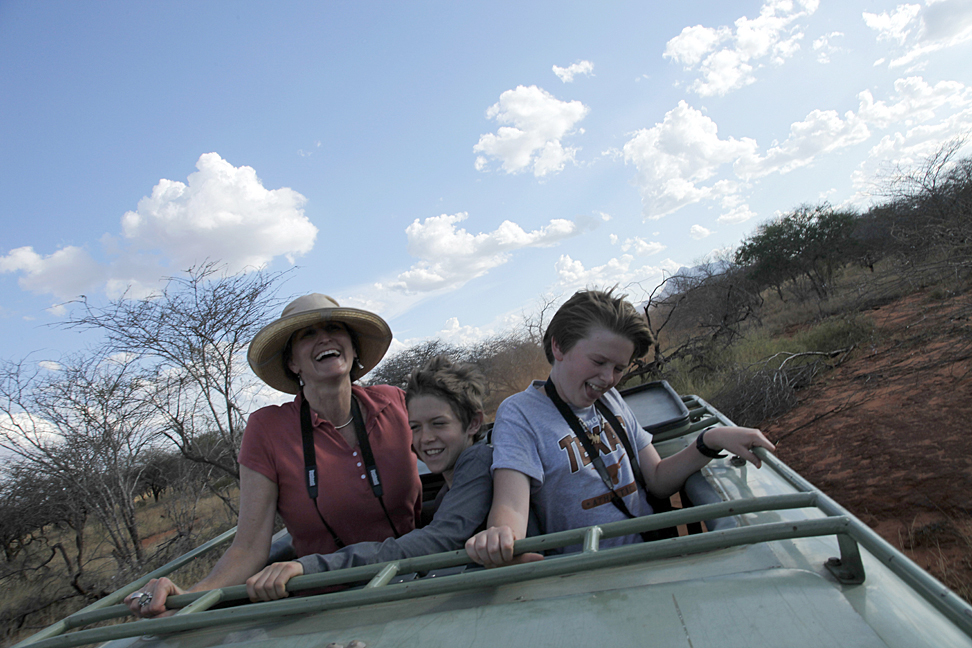 Mother and two sons riding in jeep through safari, Jeannie Ralston