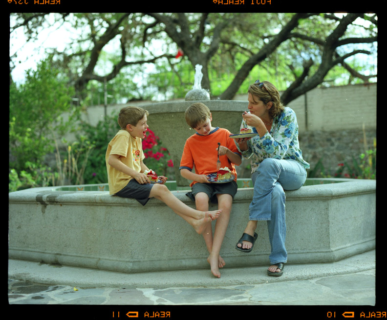 Mother and two sons sitting on edge of courtyard fountain, Jeannie Ralston, San Miguel de Allende