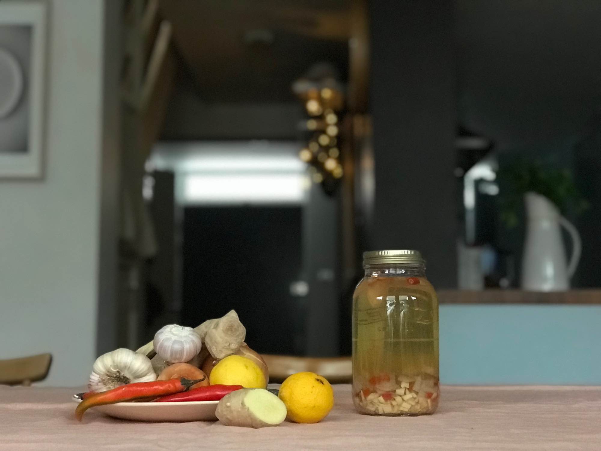 Still life of garlic, red chilli pepper, ginger lemons and jar of Dr. Ben Kim's cold/flu tonic.